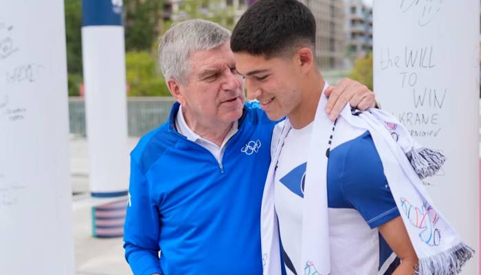 ternational Olympic Committee President Thomas Bach hugs Israeli soccer player Niv Yehoshua